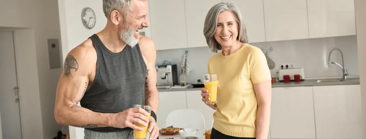 Smiling mature couple enjoying orange juice