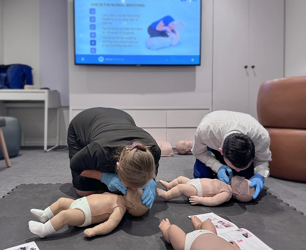 two people practicing infant CPR